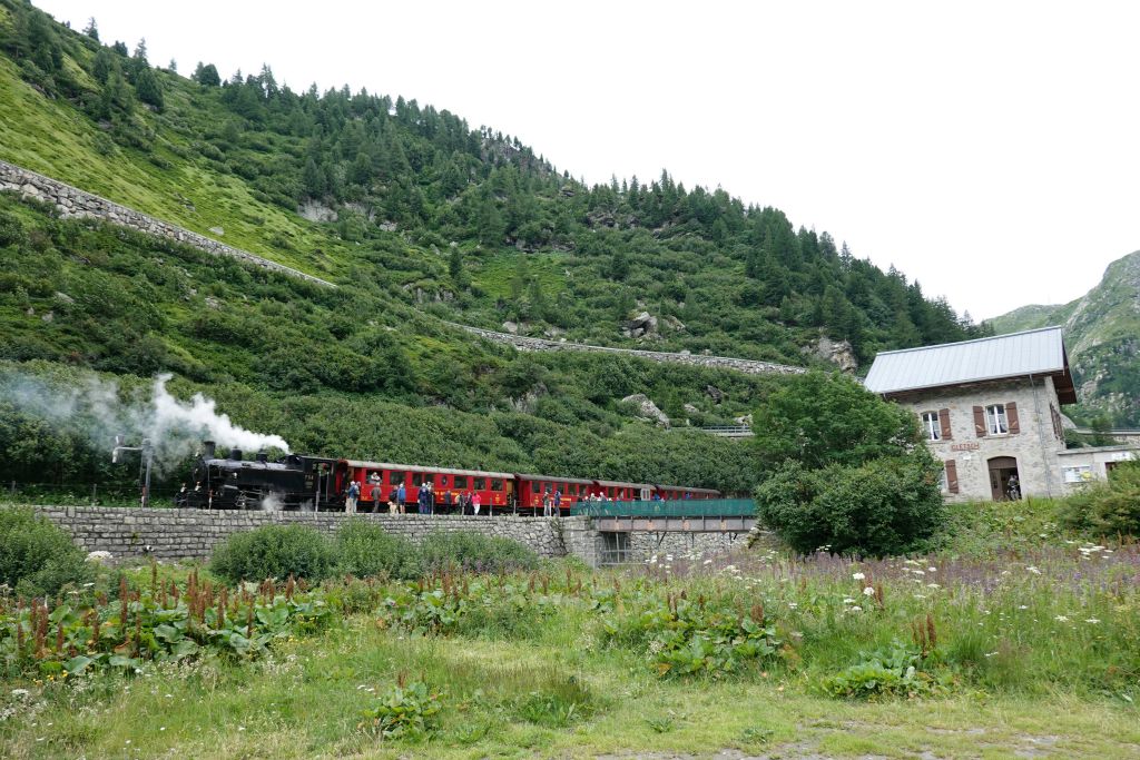Route dans la vallée du Rhône. Arrêt à Gletsch : son petit train à vapeur, sa gare